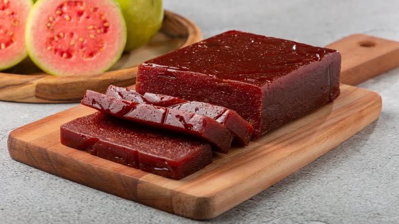 Goiabada on a wooden board with guava in background