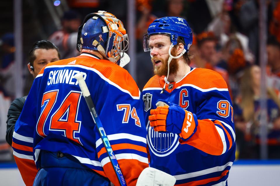 Edmonton Oilers goaltender Stuart Skinner (74) and center Connor McDavid (97) celebrate a Game 6 win against the Florida Panthers.