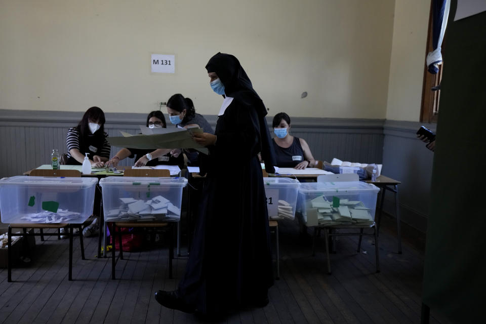 A nun walks to cast her ballot at a polling station during presidential elections in Santiago, Chile, Sunday, Nov. 21, 2021. (AP Photo/Esteban Felix)