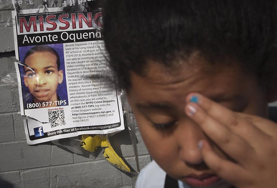 A girl turns around after looking at a missing poster for Avonte Oquendo, a missing 14-year-old autistic boy, on a wall in the Brooklyn borough of New York