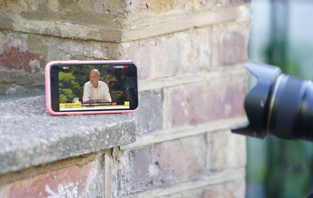 A member of the press photographs a mobile phone (Aaron Chown/PA)