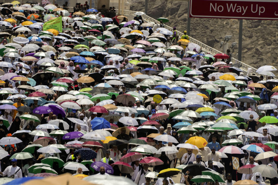 Muslim pilgrims hold umbrellas as they walk to cast stones at pillars in the symbolic stoning of the devil, the last rite of the annual Hajj, in Mina near the holy city of Mecca, Saudi Arabia, Friday, June 30, 2023. (AP Photo/Amr Nabil)