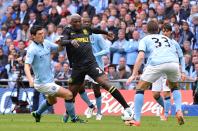 Wigan Athletic's Arouna Kone (centre) and Manchester City's Gareth Barry battle for the ball