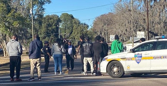 Neighbors gather Sunday as Jacksonville police investigate a fatal triple shooting in the 11200 block of Bridges Road near Dunn Avenue.