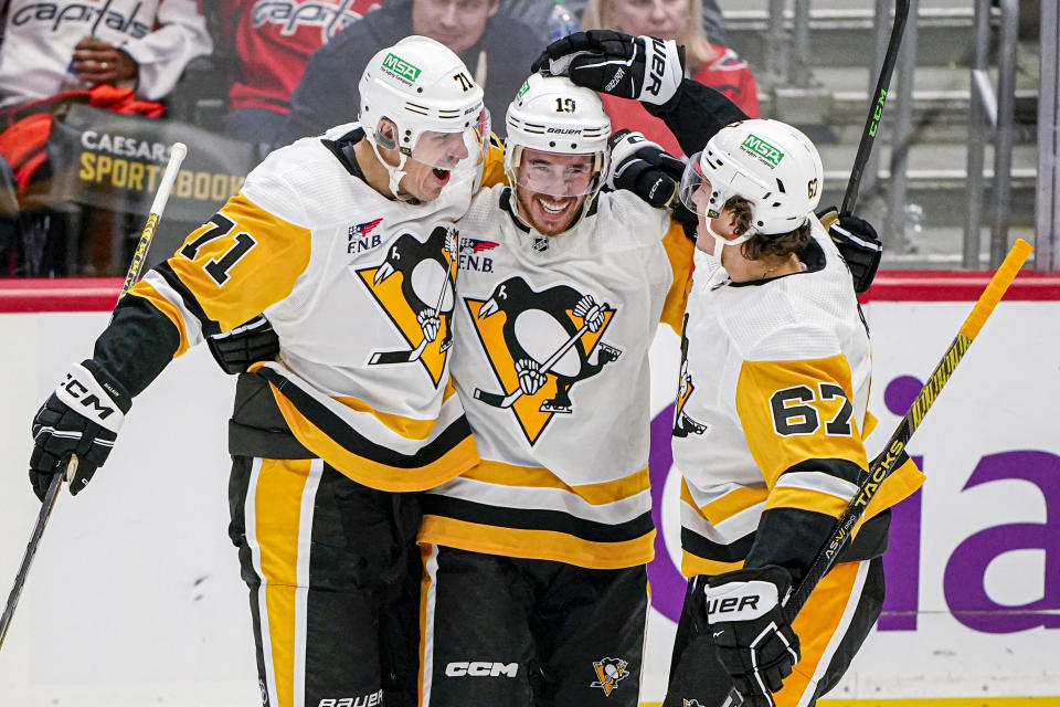 Pittsburgh Penguins right wing Reilly Smith (19) celebrates with center Evgeni Malkin (71) and right wing Rickard Rakell (67) after his goal against the Washington Capitals during the third period of an NHL hockey game Friday, Oct. 13, 2023, in Washington. (AP Photo/Andrew Harnik)