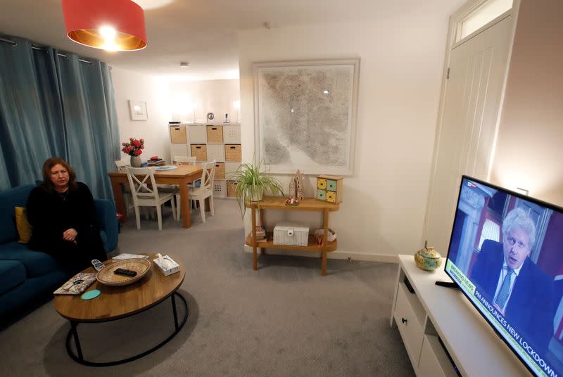 A woman watches the TV as Britain's Prime Minister Boris Johnson announces a new national lockdown amid the outbreak of the coronavirus disease (COVID-19), in Woburn Sands