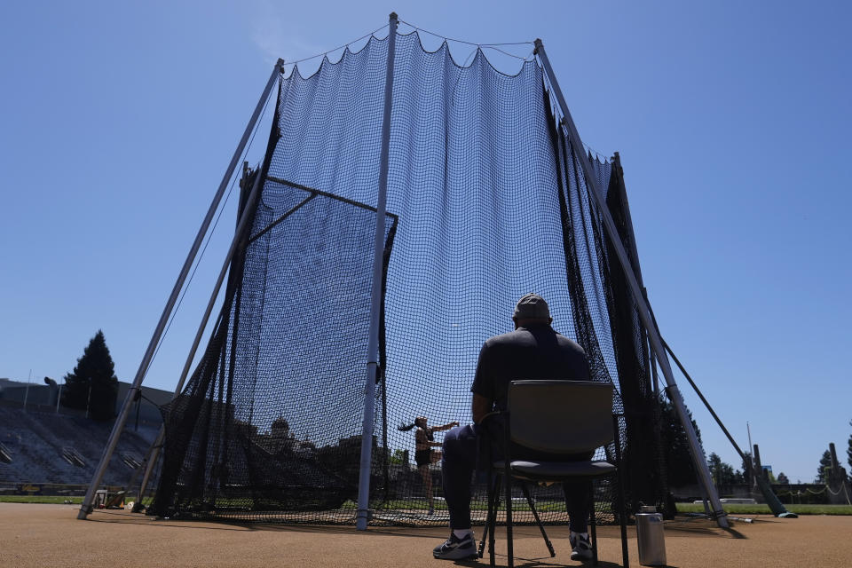 California track and field coach Mohamad Saatara, foreground, watches as Caisa-Marie Lindfors practices in Berkeley, Calif., Thursday, May 2, 2024. Saatara is at the center of a diverse team of throwers based in Northern California. The man known as Coach Mo hopes to have as many as 15 of his athletes at the Paris Olympics this summer representing multiple countries. (AP Photo/Jeff Chiu)