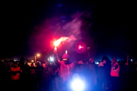 A demonstrator holds up a flare during a union strike of Chuquicamata copper mine, one of the world's largest, in Calama