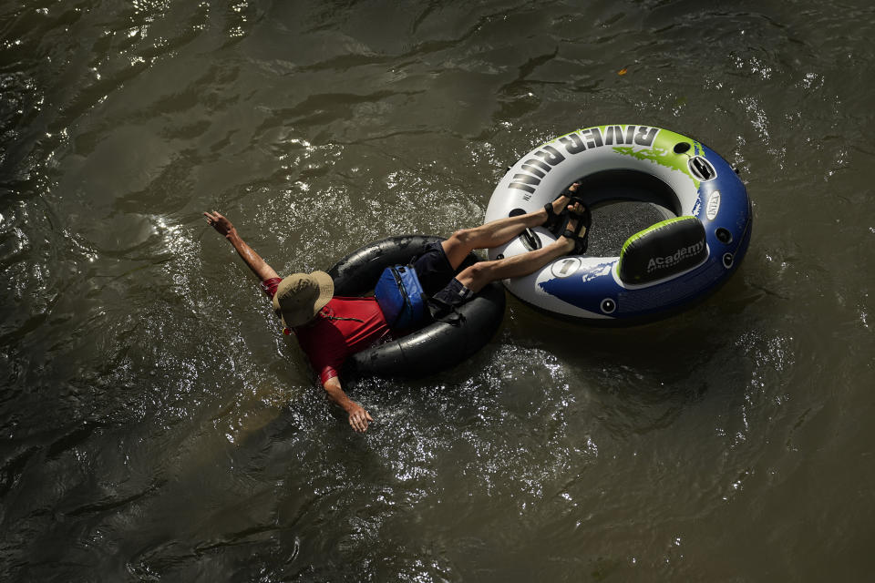FILE - A tuber floats on the Comal River, July 26, 2023, in New Braunfels, Texas, as the area continues to feel the effects of triple-digit temperatures. Nearly 60% of the U.S. population, are under a heat advisory or flood warning or watch as the high temperatures spread and new areas are told to expect severe storms. (AP Photo/Eric Gay, File)