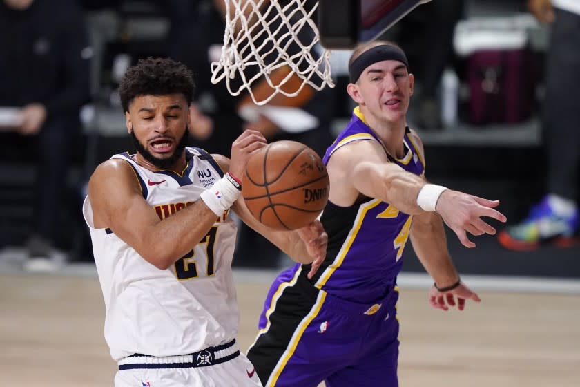 Denver Nuggets' Jamal Murray (27) and Los Angeles Lakers' Alex Caruso (4) fight for a rebound during the first half of an NBA conference final playoff basketball game Saturday, Sept. 26, 2020, in Lake Buena Vista, Fla. (AP Photo/Mark J. Terrill)