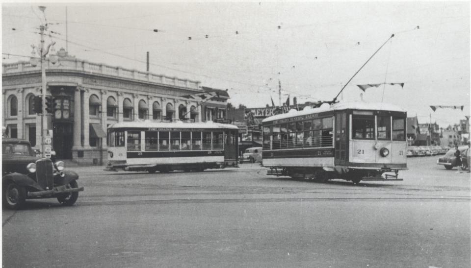 In this 1949 photograph, Birney Cars 21, in the foreground, and 25 travel near the intersection of College and Mountain Avenues in Fort Collins.