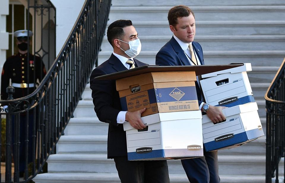 Aides carry boxes to Marine One before former President Donald Trump and wife Melania Trump departed from the White House on Trump's final day in office on Jan. 20, 2021, in Washington.