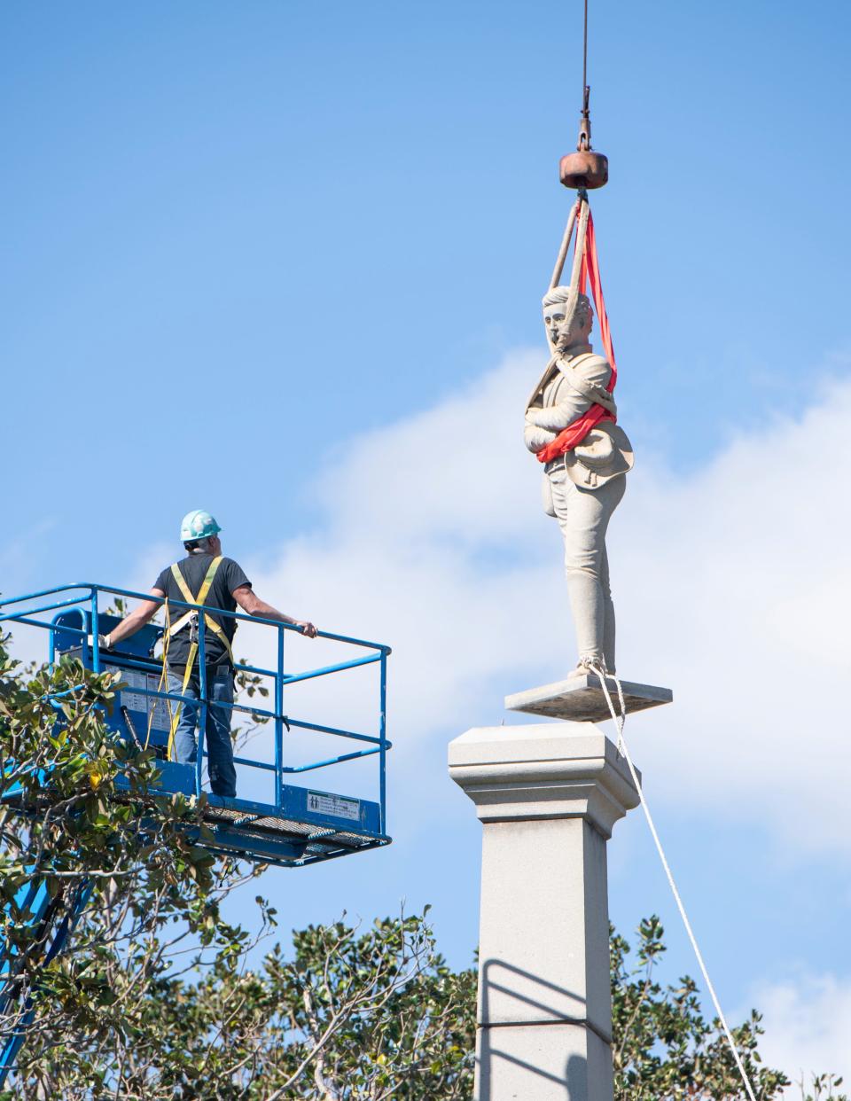 Workers remove the statue from the top of the Confederate monument in downtown Pensacola on Oct. 26, 2020.
