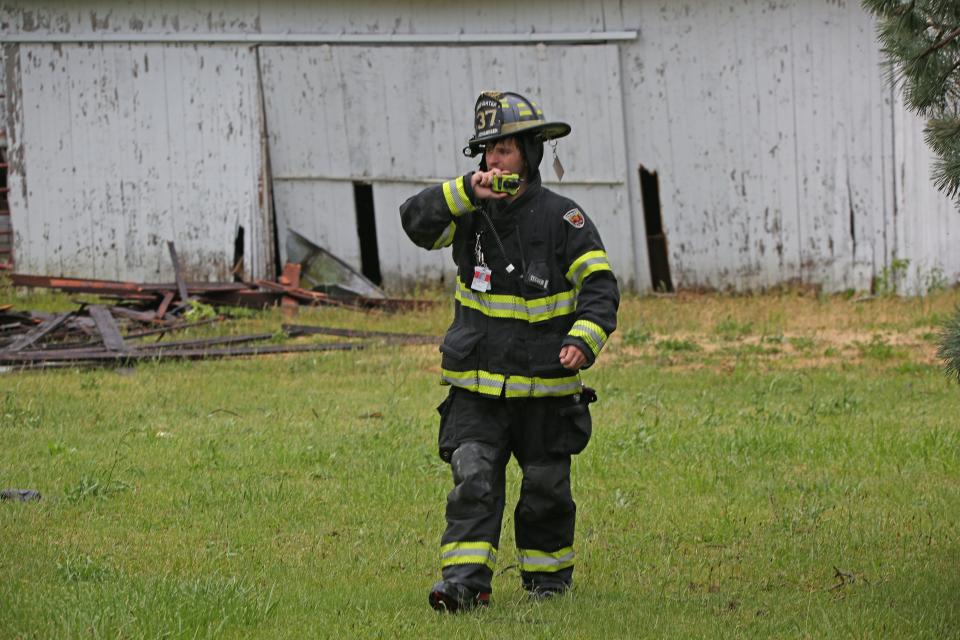 [June 15] Firefighter Trent Johannsen of the Portage Fire District surveys damage from a storm on Ohio 19 south of Oak Harbor Thursday evening.