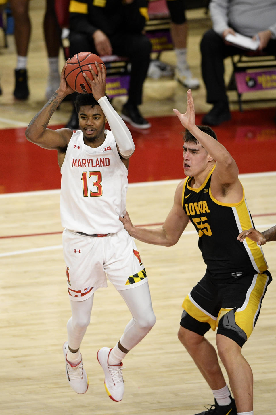 Maryland guard Hakim Hart (13) looks to pass next to Iowa center Luka Garza (55) during the first half of an NCAA college basketball game, Thursday, Jan. 7, 2021, in College Park, Md. (AP Photo/Nick Wass)