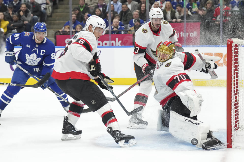 Ottawa Senators goaltender Joonas Korpisalo (70) makes a save as Toronto Maple Leafs' John Tavares, left, looks on during the second period of an NHL hockey match in Toronto, on Wednesday, Nov. 8, 2023. (Chris Young/The Canadian Press via AP)
