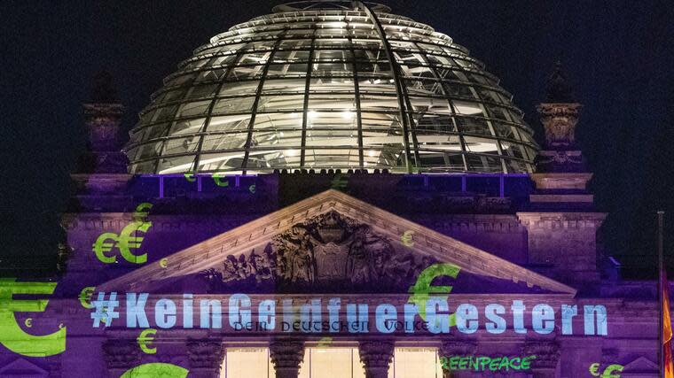 Greenpeace-Aktivisten projizieren #KeinGeldfuerGestern auf den Reichstag. Foto: dpa