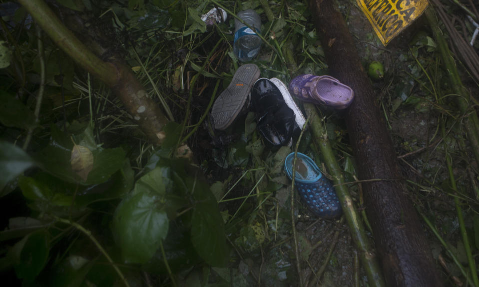 Shoes lie on the ground after a mudslide on the outskirts of El Choro, Bolivia, Saturday, Feb. 2, 2019. According to police, at least five people died and others were injured after vehicles were dragged Saturday by a mudslide on a mountainous road in the north of La Paz. (AP Photo/Juan Karita)