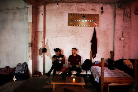 Fernanda (L), 20, and Aleksander, 23, who are among members of lesbian, gay, bisexual and transgender (LGBT) community, that have been invited to live in a building that the roofless movement has occupied, sit on a makeshift sofa, in downtown Sao Paulo, Brazil, November 16, 2016. REUTERS/Nacho Doce