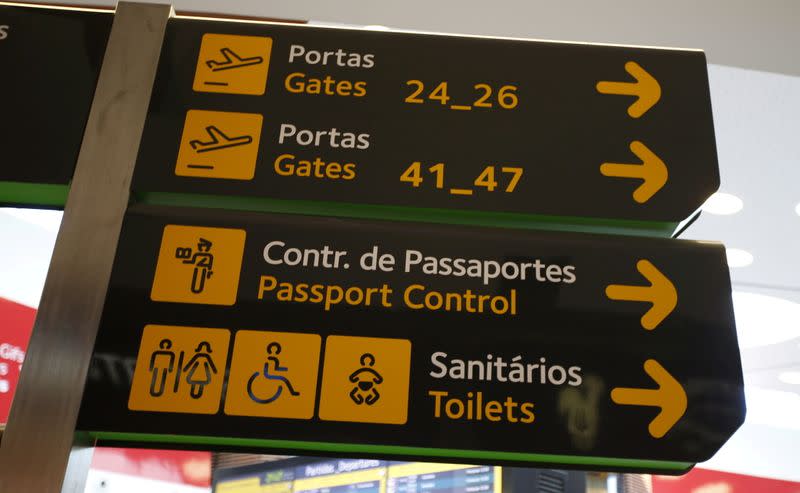 FILE PHOTO: Gates, passport control and toilets signs are seen at Lisbon's airport