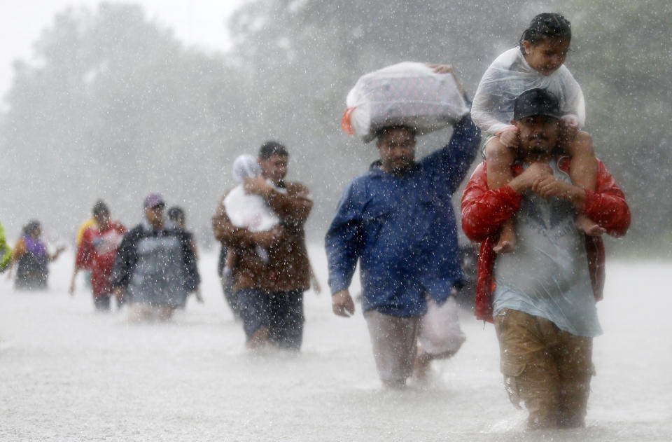 Houston residents&nbsp;wade through floodwaters on Aug. 28. (Photo: Jonathan Bachman / Reuters)