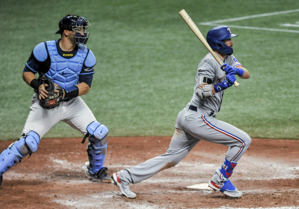 Texas Rangers' David Dahl watches his two-run double next to Tamp Bay Rays catcher Mike Zunino during the seventh inning of a baseball game Wednesday, April 14, 2021, in St. Petersburg, Fla. (AP Photo/Steve Nesius)