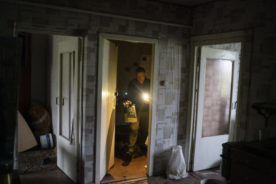 Anatolii Klyzhen carries an empty Russian army food ration packet that was left in his apartment while occupied by the Russian soldiers in the freed village of Hrakove, Ukraine, Tuesday, Sept. 13, 2022. Russian troops occupied this small village southeast of Ukraine’s second largest city of Kharkiv for six months before suddenly abandoning it around Sept. 9 as Ukrainian forces advanced in a lightning-swift counteroffensive that swept southward. (AP Photo/Leo Correa)