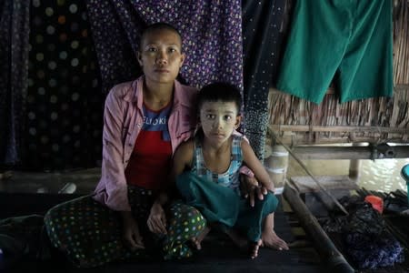 Hle Hle Saw, a victim of a domestic violence poses with her son in the village around Shwelaung, Ayeyarwady