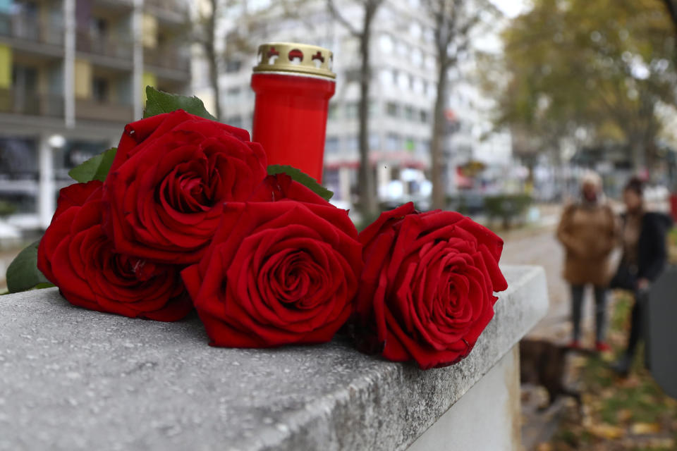 Roses lay besides a candle in Vienna, Austria, Tuesday, Nov. 3, 2020. Police in the Austrian capital said several shots were fired shortly after 8 p.m. local time on Monday, Nov. 2, in a lively street in the city center of Vienna. Austria's top security official said authorities believe there were several gunmen involved and that a police operation was still ongoing. (AP Photo/Matthias Schrader)