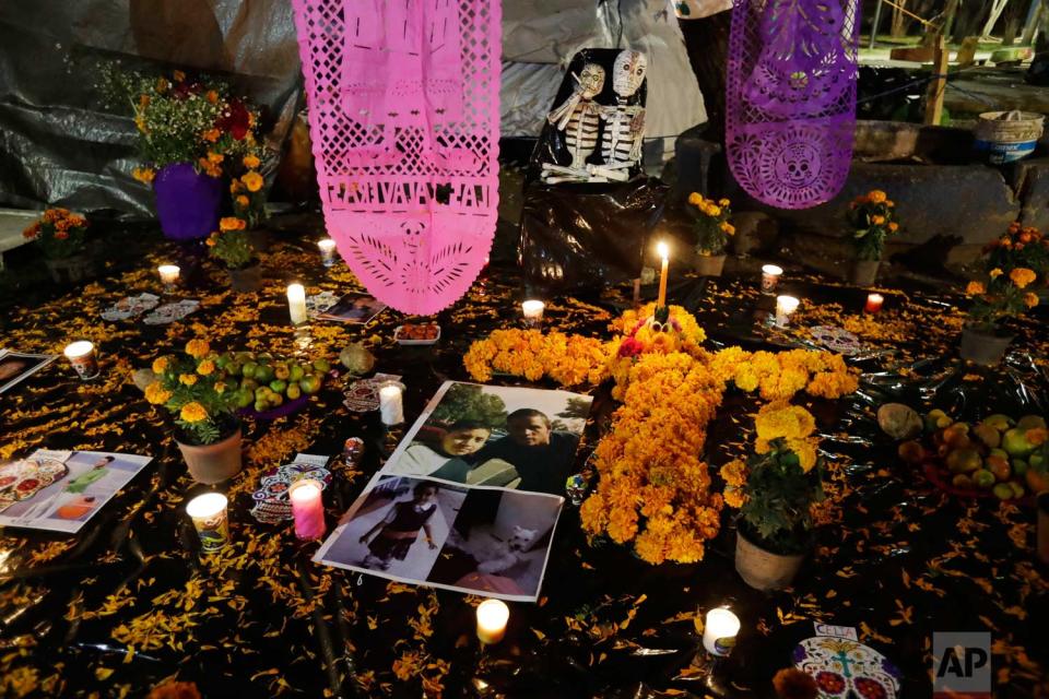 <p>Pictures of Julian Flores, 11, and his little sister Ximena, 6, lie amidst flowers and candles in a Day of the Dead altar erected in a tent camp outside Mulitfamiliar Tlalpan, where nine people including Nayeli Flores’ two children were killed when a building collapsed in the Sept. 19 earthquake. (AP Photo/Rebecca Blackwell) </p>