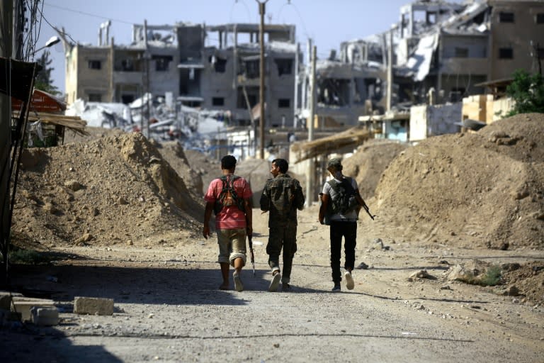 Members of the US-backed Syrian Democratic Forces are seen in the neighborhood of Nazlet Shehadeh, from the western side of the Syrian city of Raqa