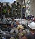 <p>A rescuer pulls a dog out of the rubble during the search for survivors in Mexico City on Sept. 20, 2017 after a strong quake hit central Mexico. (Photo: Yuri Cortez/AFP/Getty Images) </p>