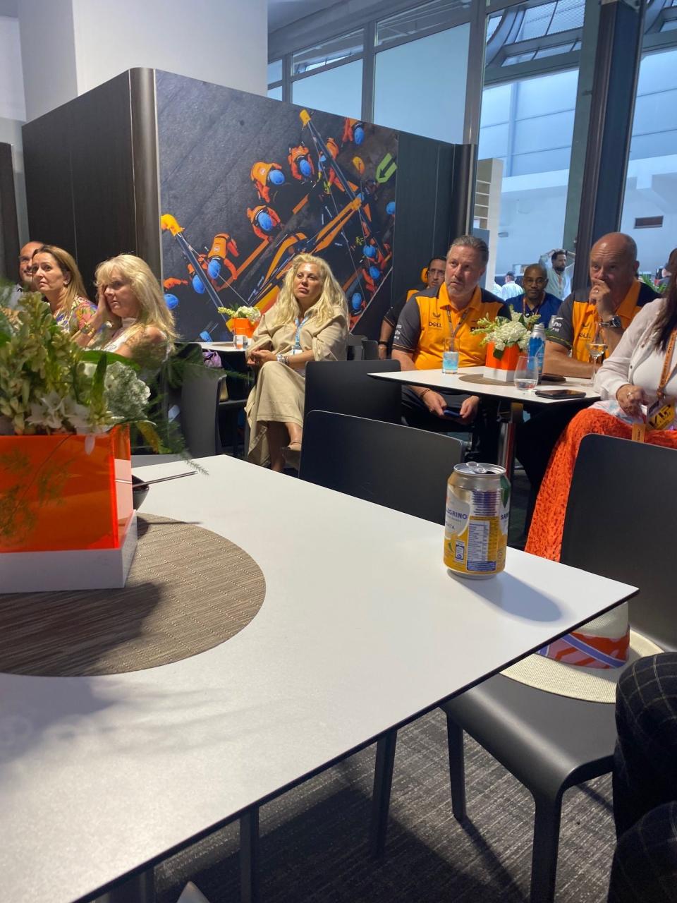 McLaren Racing CEO Zak Brown (center-right) sits and watches his team in the Miami Grand Prix inside McLaren hospitality.