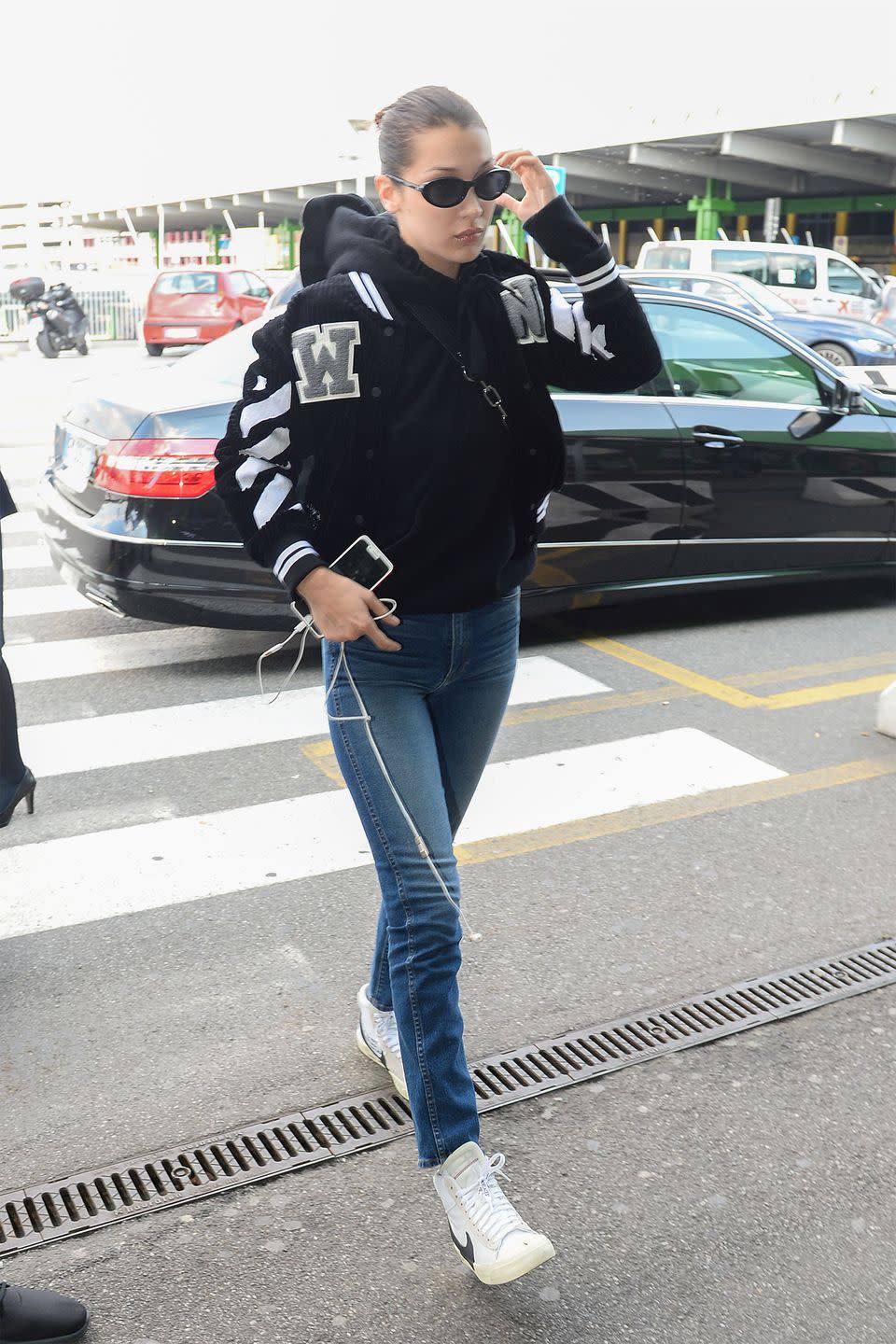 <p>In an Off-White c/o Virgil Abloh varsity jacket with jeans, Nike sneakers, an Alexander Wang fanny pack and Roberi & Fraud sunglasses while heading to the airport in Milan. </p>