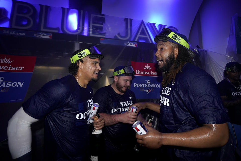 Toronto Blue Jays' Vladimir Guerrero Jr., right, celebrates alongside teammates in the locker room after clinching a berth in the AL wild card series following a baseball game against the Tampa Bay Rays in Toronto, Sunday, Oct. 1, 2023. (Frank Gunn/The Canadian Press via AP)