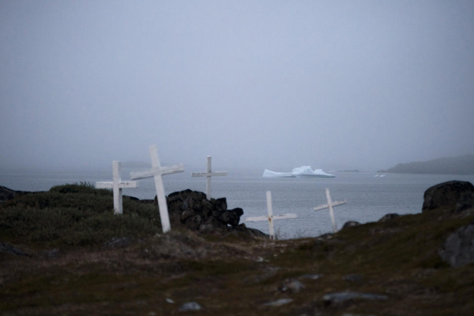 An iceberg floats near a cemetery in Kulusuk, Greenland, early Thursday, Aug. 15, 2019. Greenland has been melting faster in the last decade and this summer, it has seen two of the biggest melts on record since 2012. (AP Photo/Felipe Dana)