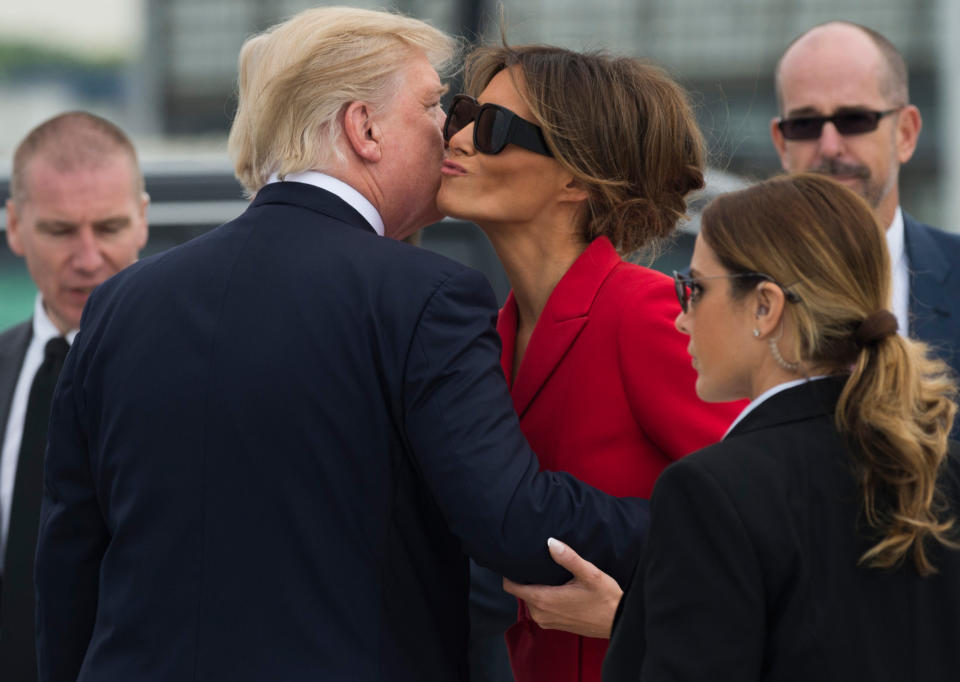 President Donald Trump kisses First Lady Melania Trump after disembarking form Air Force One upon arrival at Paris Orly airport on July 13, 2017, beginning a 24-hour trip that coincides with France's national day and the 100th anniversary of US involvement in World War I. Donald Trump arrived in Paris for a presidential visit filled with Bastille Day pomp and which the White House hopes will offer respite from rolling scandal backing home.&nbsp;