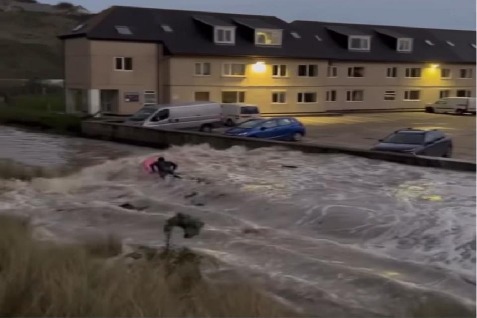 A surfer rides the swollen river in Perranporth <i>(Image: Timothy Job)</i>