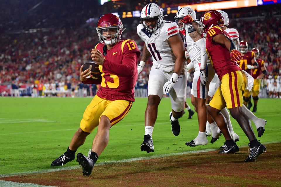 USC quarterback Caleb Williams (13) scores a touchdown against the Arizona Wildcats during the first half at Los Angeles Memorial Coliseum.