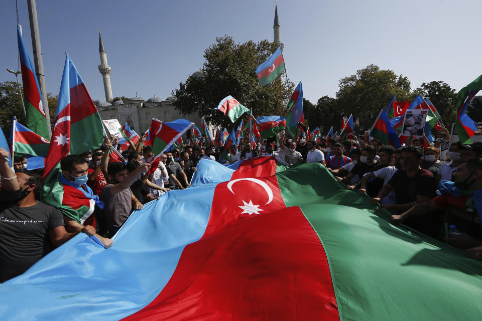 Demonstrators holding Azerbaijan flags chant slogans during a protest supporting Azerbaijan, in Istanbul, Sunday, Oct. 4, 2020. Armenian and Azerbaijani forces continue their fighting over the separatist region of Nagorno-Karabakh, following the reigniting of a decades-old conflict. Turkey, which strongly backs Azerbaijan, has condemned an attack on Azerbaijan's second largest city Gence and said the attack was proof of Armenia's disregard for law. (AP Photo/Emrah Gurel)