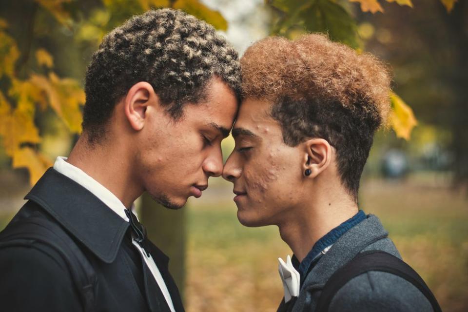 two men resting their foreheads on each other