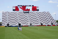 CF Montreal and Toronto FC players stand for the national anthem in a nearly empty DRV PNK Stadium during the first half of an MLS soccer match, Saturday, April 17, 2021, in Fort Lauderdale, Fla. CF Montreal is playing the first part of their season in Inter Miami's stadium due to the coronavirus pandemic. (AP Photo/Lynne Sladky)