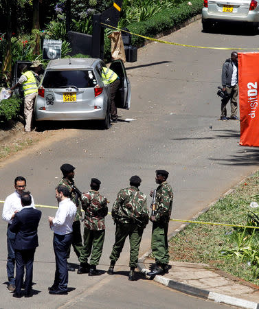 Kenyan policemen and explosives experts gather evidence from the car suspected to have been used by the attackers outside the scene where explosions and gunshots were heard at The DusitD2 complex, in Nairobi, Kenya January 17, 2019. REUTERS/Njeri Mwangi