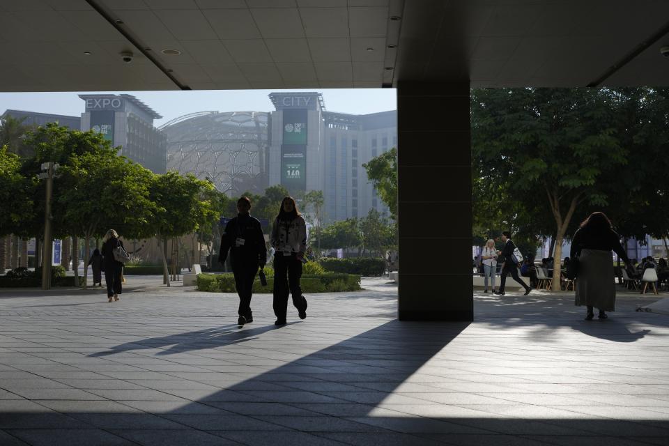 People walk through the COP28 U.N. Climate Summit, Wednesday, Dec. 6, 2023, in Dubai, United Arab Emirates. (AP Photo/Rafiq Maqbool)