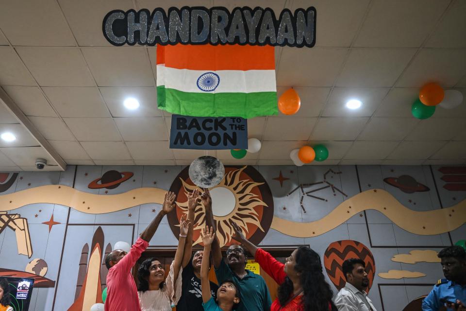 Visitors touch a picture of the moon at Nehru planetarium as they gather to witness the landing of the Indian Space Research Organisation's (ISRO) Chandrayaan-3 on the moon, in New Delhi on August 23, 2023. India readied on August 23 to become the first nation to land a spacecraft on the Moon's south pole, days after a Russian probe crashed in the same region.