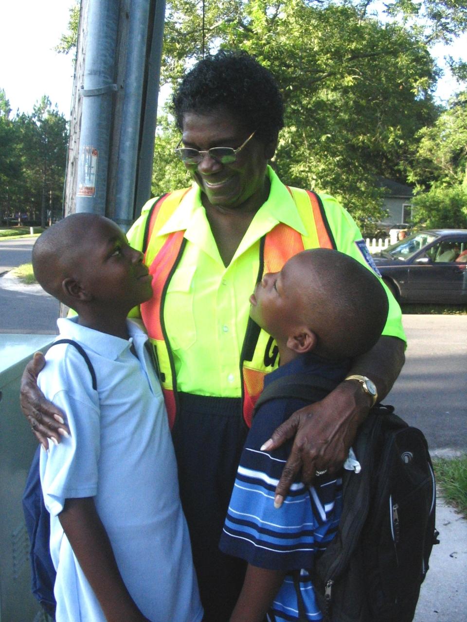 In 2006, Thelma Ray, a crossing guard for 14 years, gets a hug from brothers David (left), 9, and Dakoby Jones, 8, on the first day of school at Pine Forest Elementary School of the Arts. Her relationship with Pine Forest goes back to its opening in 1963 when she was its first PTA president. In 2007 she was among those honored at an annual hall of fame banquet for the J.P. Small Foundation, which helps youths build development skills.