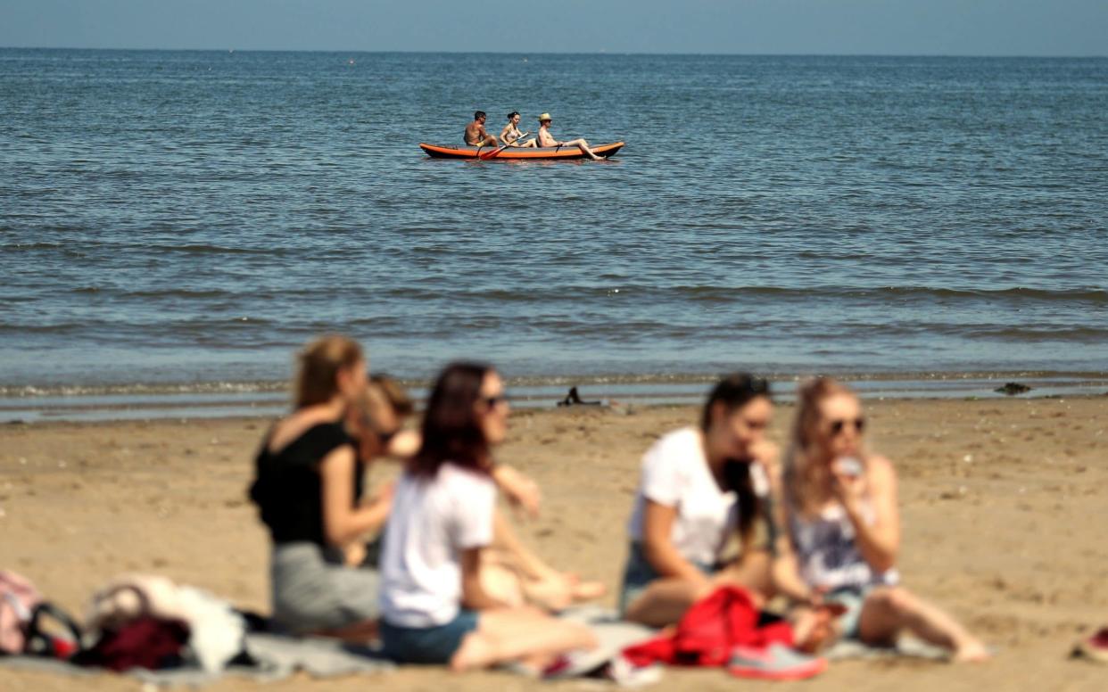 Siblings Zoltan, Anna and Peter enjoy the sunshine whilst kayaking at Portobello beach, Edinburgh - PA