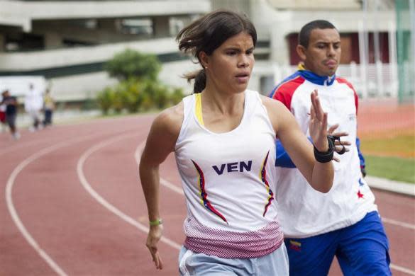 Irene Suarez, 24, a blind runner and her guide Richard Torrealba run during a training session as part of her Paralympic training route in Caracas March 21, 2012.