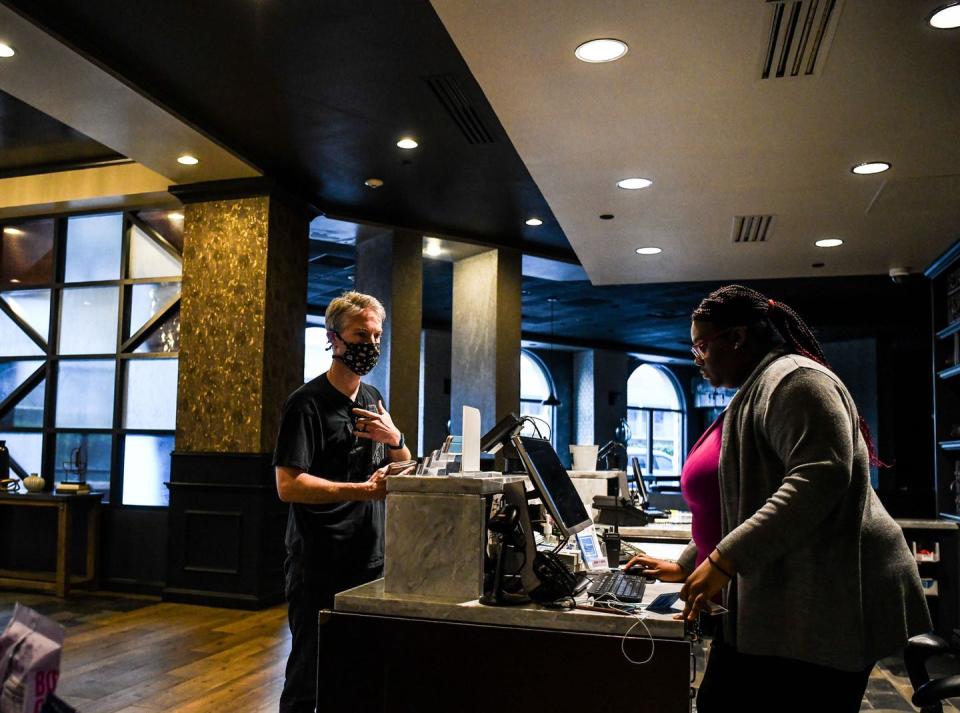 <span class="caption">A tourist checks into a hotel in Savannah, Ga., on April 25, 2020, shortly after Georgia Gov. Brian Kemp lifted some social distancing measures.</span> <span class="attribution"><a class="link " href="https://www.gettyimages.com/detail/news-photo/tourist-wears-a-mask-amid-fears-over-the-spread-of-the-news-photo/1211025499?adppopup=true" rel="nofollow noopener" target="_blank" data-ylk="slk:Chandan Khanna/AFP via Getty Images;elm:context_link;itc:0;sec:content-canvas">Chandan Khanna/AFP via Getty Images</a></span>