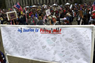 A banner filled with signatures of state employees who may lose their jobs after the Oct. 4 deadline requiring their full vaccination stands on display as people fill the Capitol campus in Olympia, Wash., Sunday, Oct. 3, 2021, to rally against the COVID-19 vaccination mandate by Gov. Jay Inlsee. (Steve Bloom/The Olympian via AP)